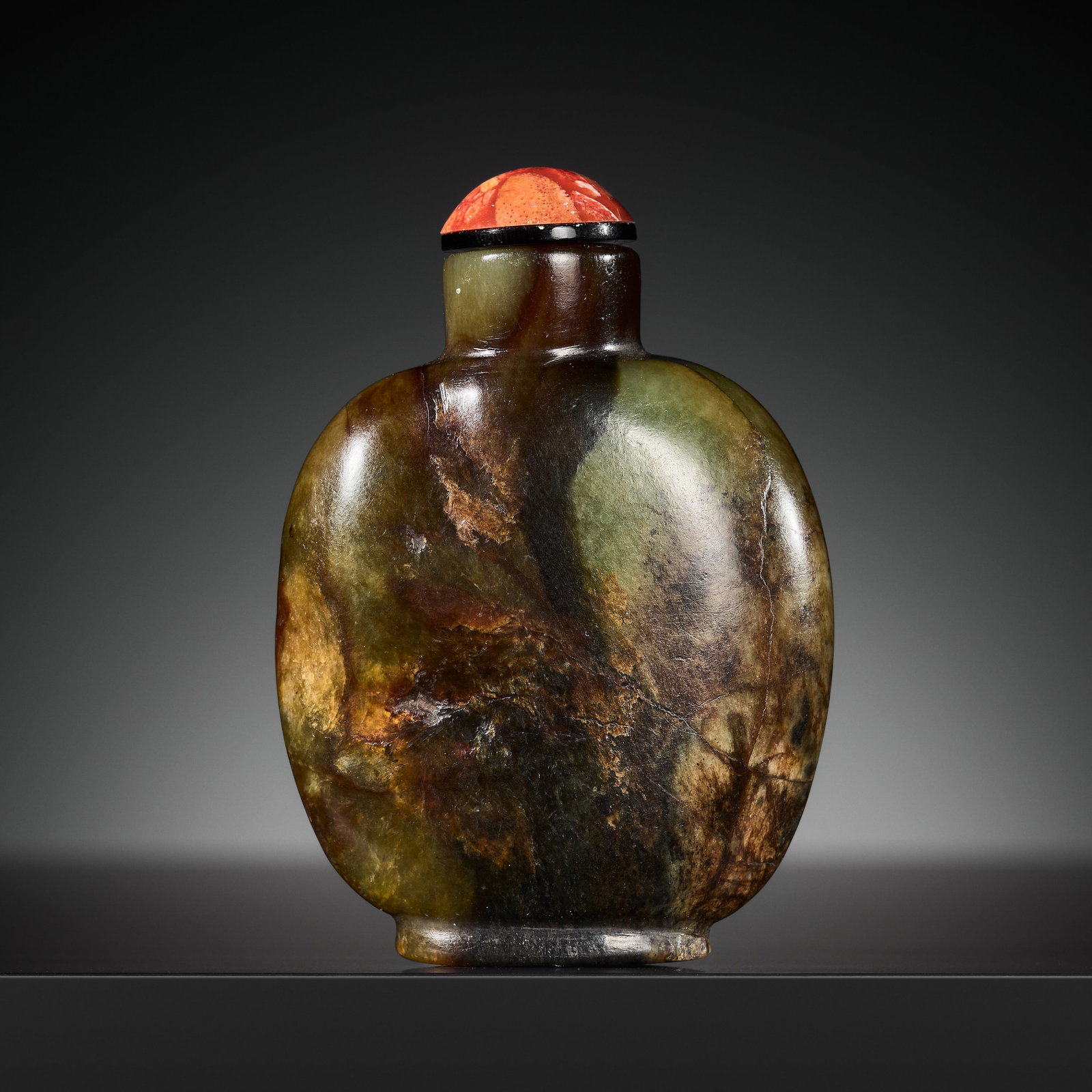 A DEEP CELADON, RUSSET, AND BROWN JADE SNUFF BOTTLE, 18TH-19TH CENTURY: A DEEP CELADON, RUSSET, AND BROWN JADE SNUFF BOTTLE, 18TH-19TH CENTURY China. The bottle of rounded rectangular form, supported on a short oval foot ring, and surmounted by a short cylindrical neck. T