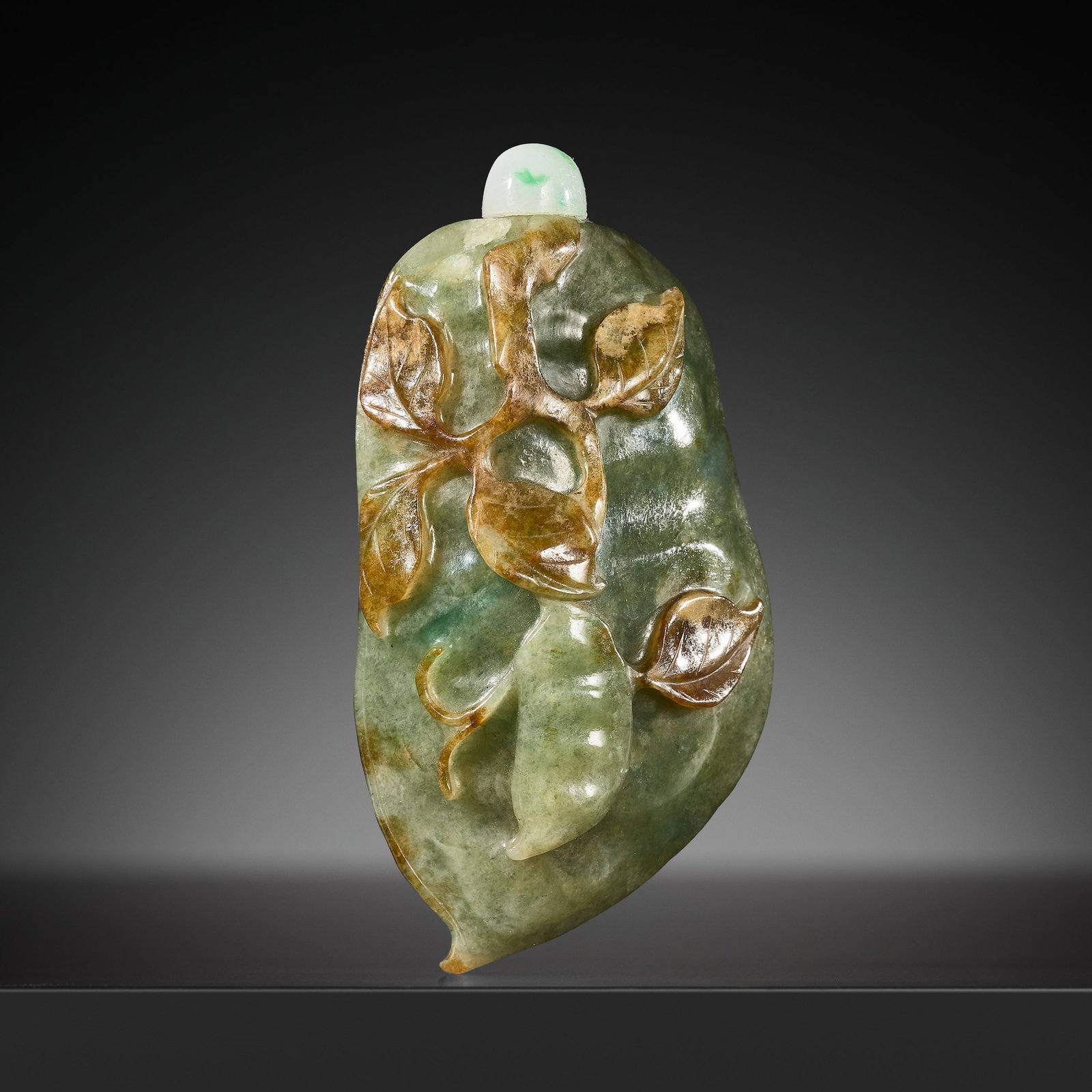 A SPINACH GREEN AND RUSSET JADE 'PEA POD' SNUFF BOTTLE, 19TH CENTURY: A SPINACH GREEN AND RUSSET JADE 'PEA POD' SNUFF BOTTLE, 19TH CENTURY China. Intricately formed in the shape of a pea pod, borne on a gnarled branch issuing a smaller pod in high relief, the body furth
