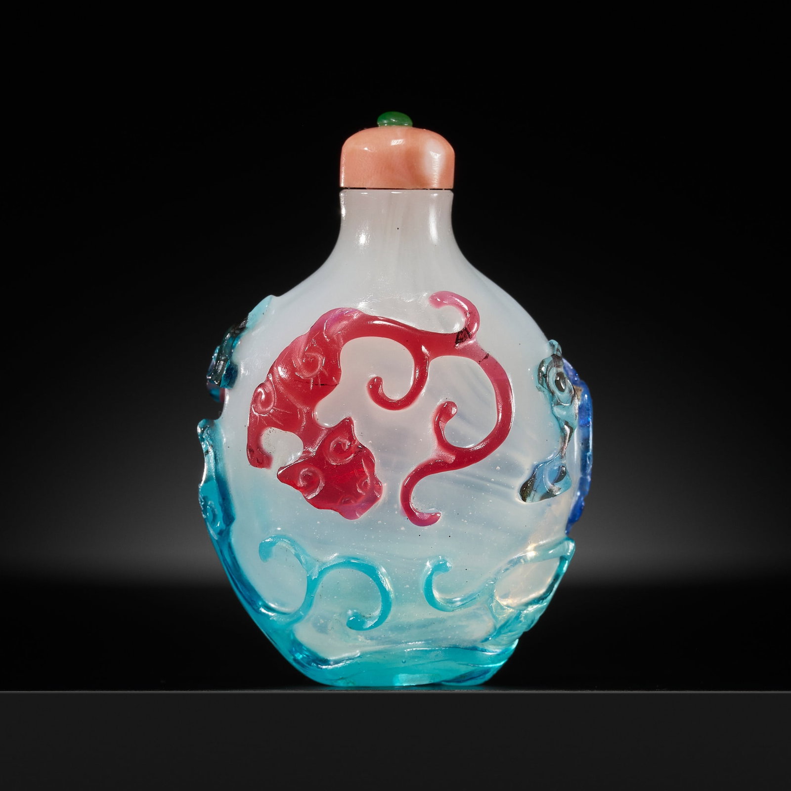 A PRISTINE THREE-COLOR OVERLAY 'THREE CHILONG' WHITE GLASS SNUFF BOTTLE, 1740-1860: A PRISTINE THREE-COLOR OVERLAY 'THREE CHILONG' WHITE GLASS SNUFF BOTTLE, 1740-1860 China. Of ovoid form tapering towards the foot and rising to a short waisted neck with flat lip, the semi-transparent