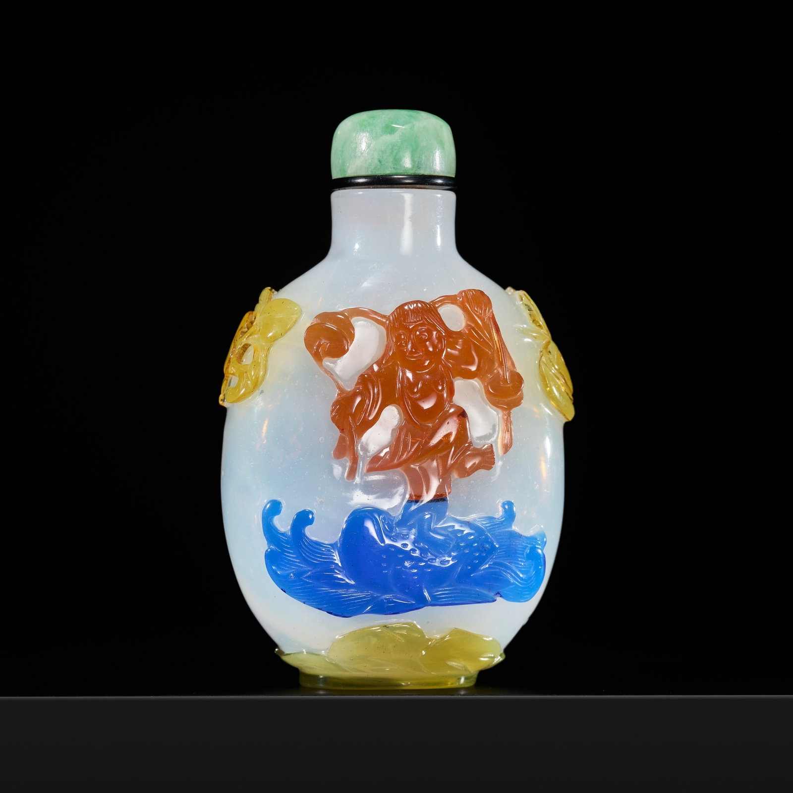 A PRISTINE FOUR-COLOR OVERLAY 'ZHONG KUI AND LIU HAI' MILKY-WHITE GLASS SNUFF BOTTLE, MID-QING: A PRISTINE FOUR-COLOR OVERLAY 'ZHONG KUI AND LIU HAI' MILKY-WHITE GLASS SNUFF BOTTLE, MID-QING DYNASTY China, 18th to early 19th century. Of flattened ovoid form, rising from an oval foot to a gently 