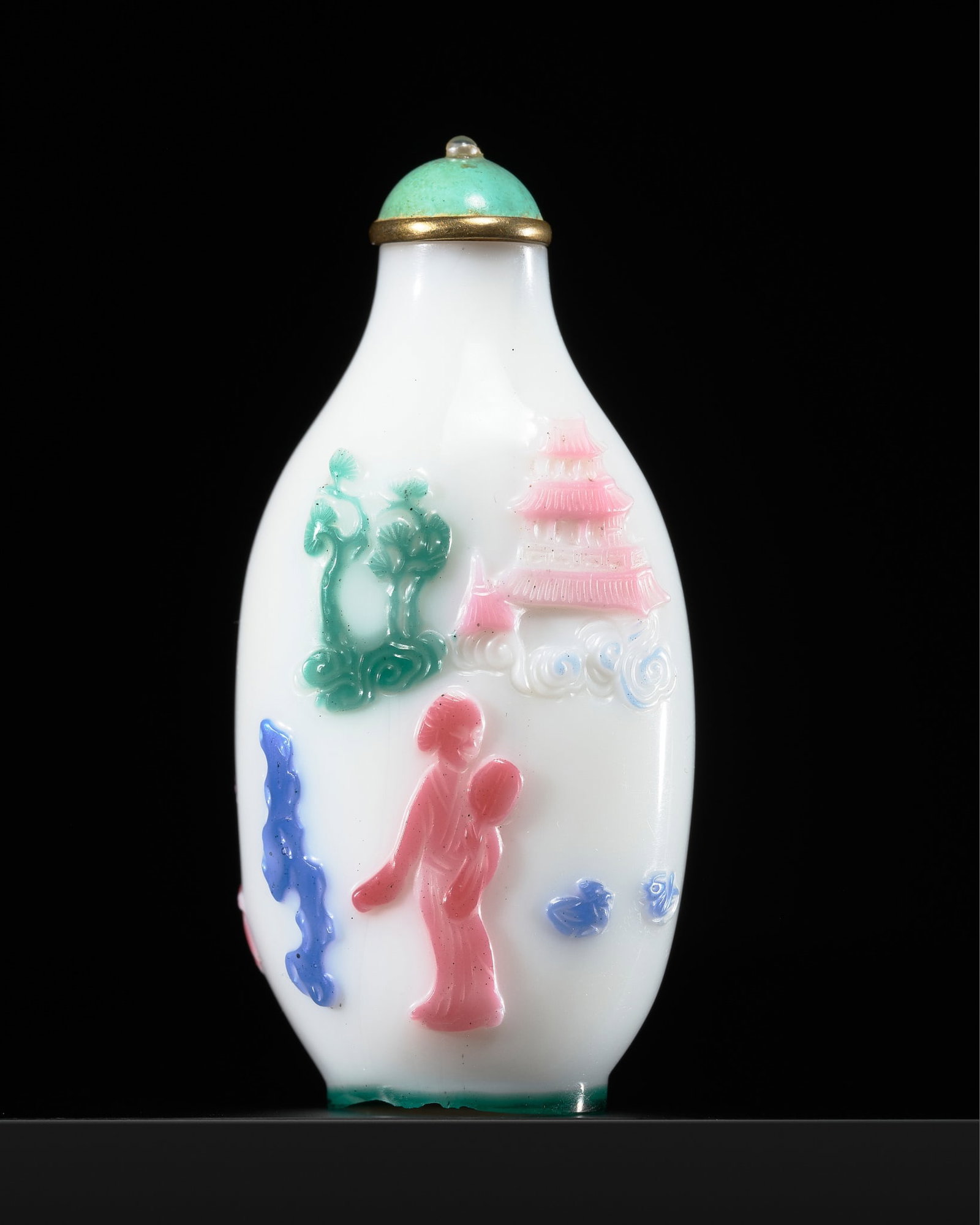 A RARE FIVE-COLOR OVERLAY WHITE GLASS SNUFF BOTTLE, YANGZHOU SCHOOL, 1820-1890: A RARE FIVE-COLOR OVERLAY WHITE GLASS SNUFF BOTTLE, YANGZHOU SCHOOL, 1820-1890 China. Of elongated oval form rising from a green lined oval foot to a cylindrical neck with flat lip, finely carved thro