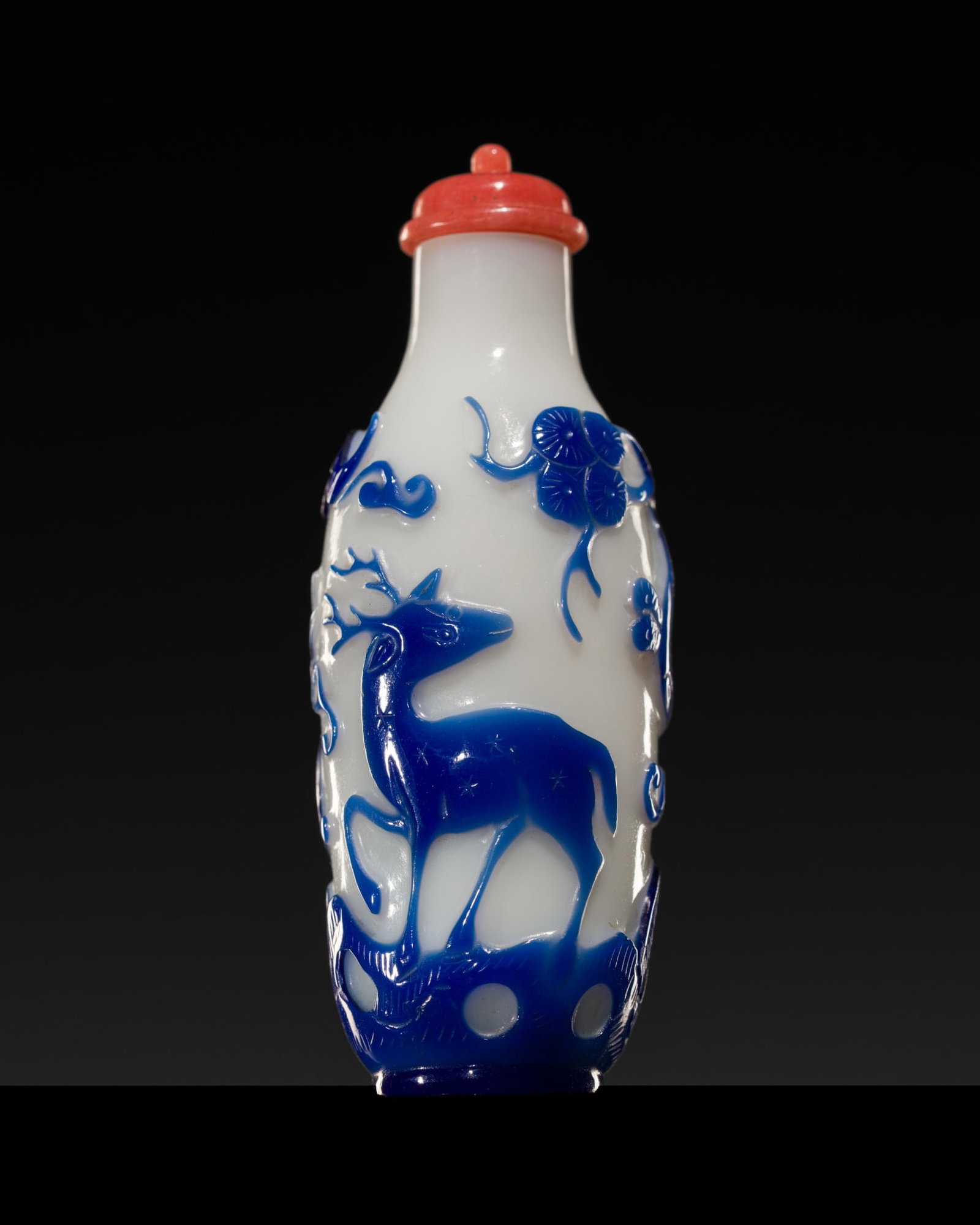 A BLUE OVERLAY 'LONGEVITY' WHITE GLASS SNUFF BOTTLE, 1790-1850: A BLUE OVERLAY 'LONGEVITY' WHITE GLASS SNUFF BOTTLE, 1790-1850 China probably imperial glassworks, Beijing. Of slender ovoid form, supported on a circular foot and rising to a cylindrical neck with fl