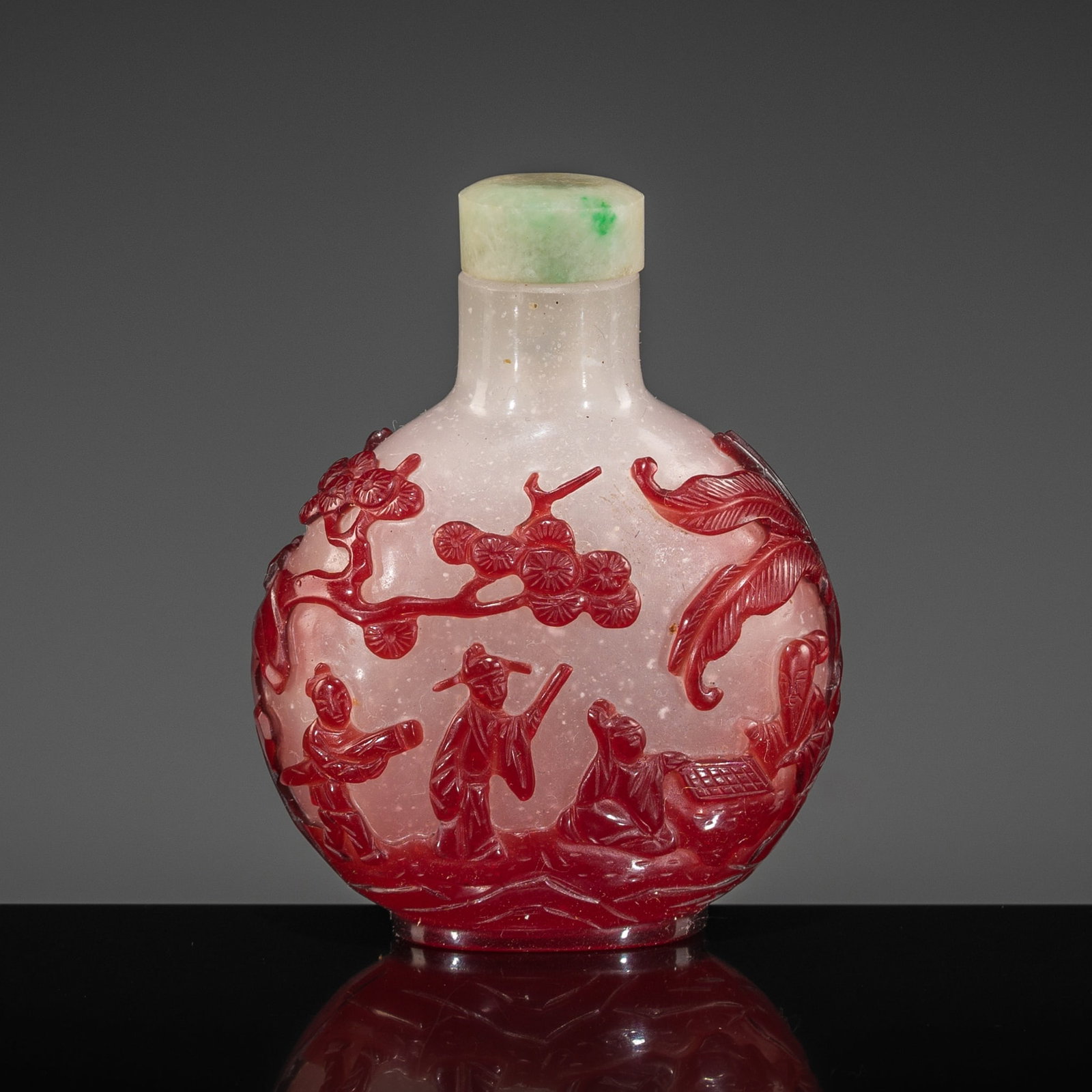 A RUBY-RED OVERLAY 'SCHOLARS AT LEISURE' SNOWFLAKE GLASS SNUFF BOTTLE, 1730-1780: A RUBY-RED OVERLAY 'SCHOLARS AT LEISURE' SNOWFLAKE GLASS SNUFF BOTTLE, 1730-1780 China. Of compressed globular form, rising from an oval foot to a cylindrical neck with a flat lip, this bottle is meti