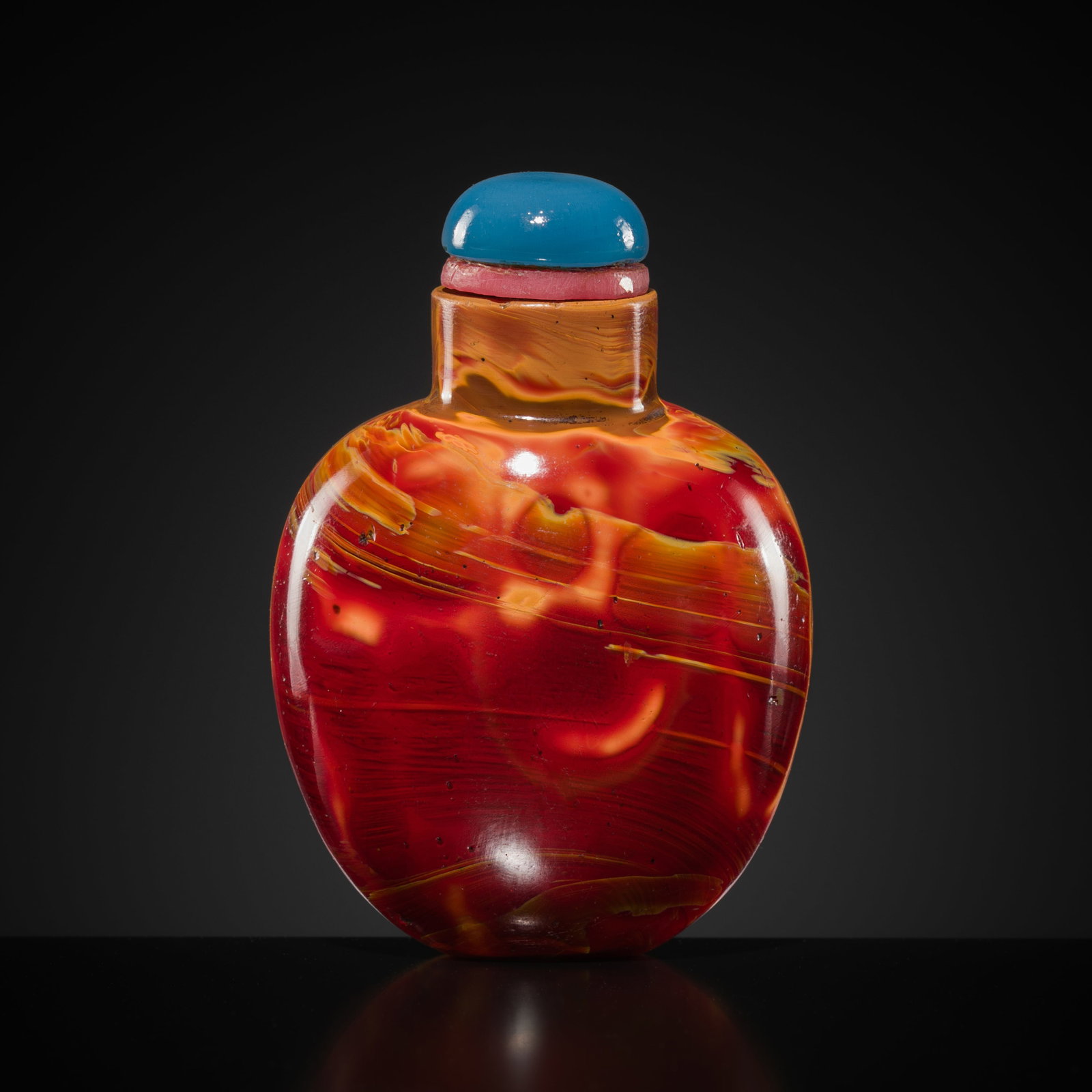 AN IMITATION 'REALGAR' GLASS SNUFF BOTTLE, 19TH CENTURY: AN IMITATION 'REALGAR' GLASS SNUFF BOTTLE, 19TH CENTURY China. Of oval spade form, raised on a concave foot and rising to a cylindrical neck with a flat lip. The body is of ruby-red, orange-yellow and