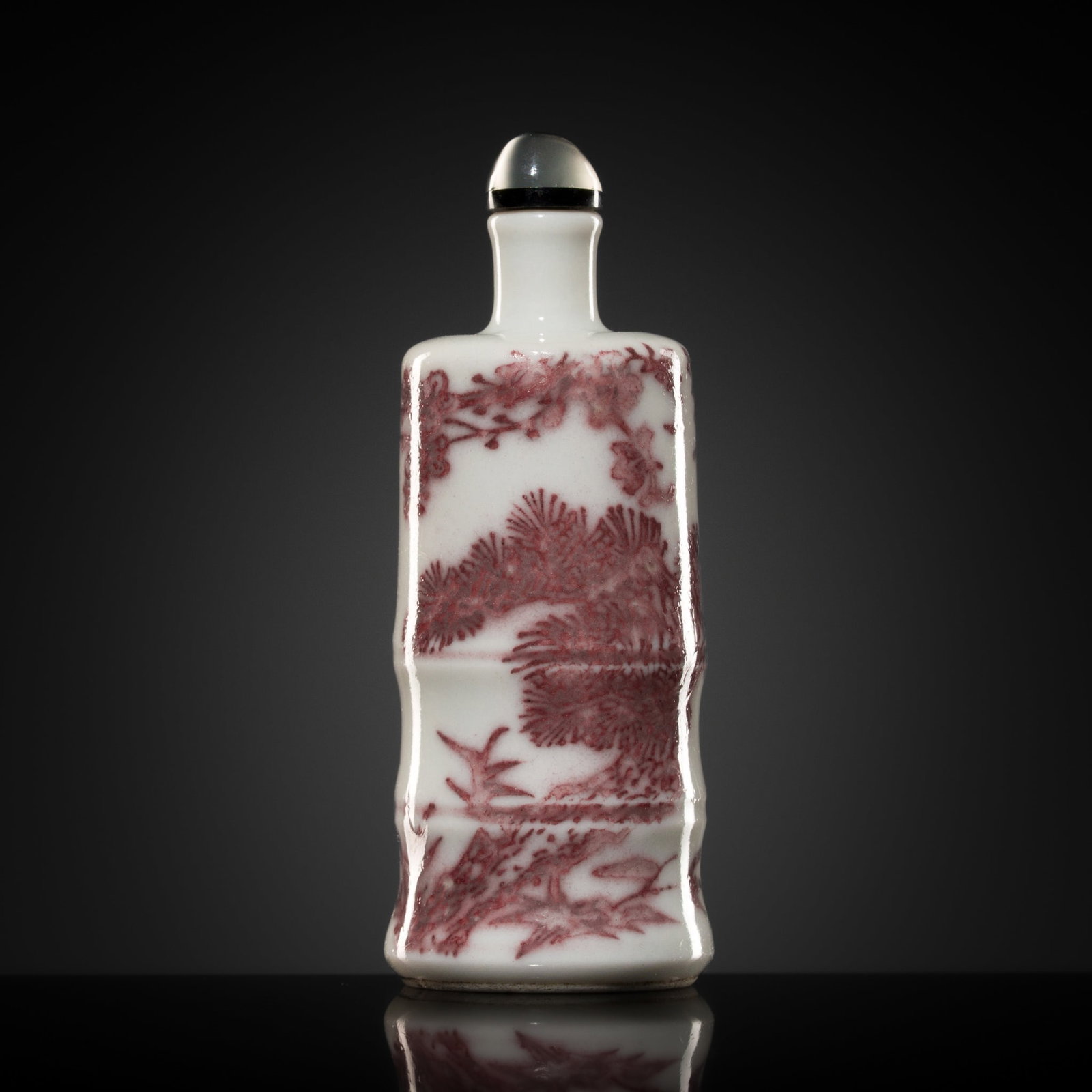 A COPPER RED 'THREE FRIENDS OF WINTER' PORCELAIN SNUFF BOTTLE, 19TH CENTURY: A COPPER RED 'THREE FRIENDS OF WINTER' PORCELAIN SNUFF BOTTLE, 19TH CENTURY China. Of neatly potted bamboo form, surmounted by a thin tubular neck and raised on circular foot, the exterior sides paint