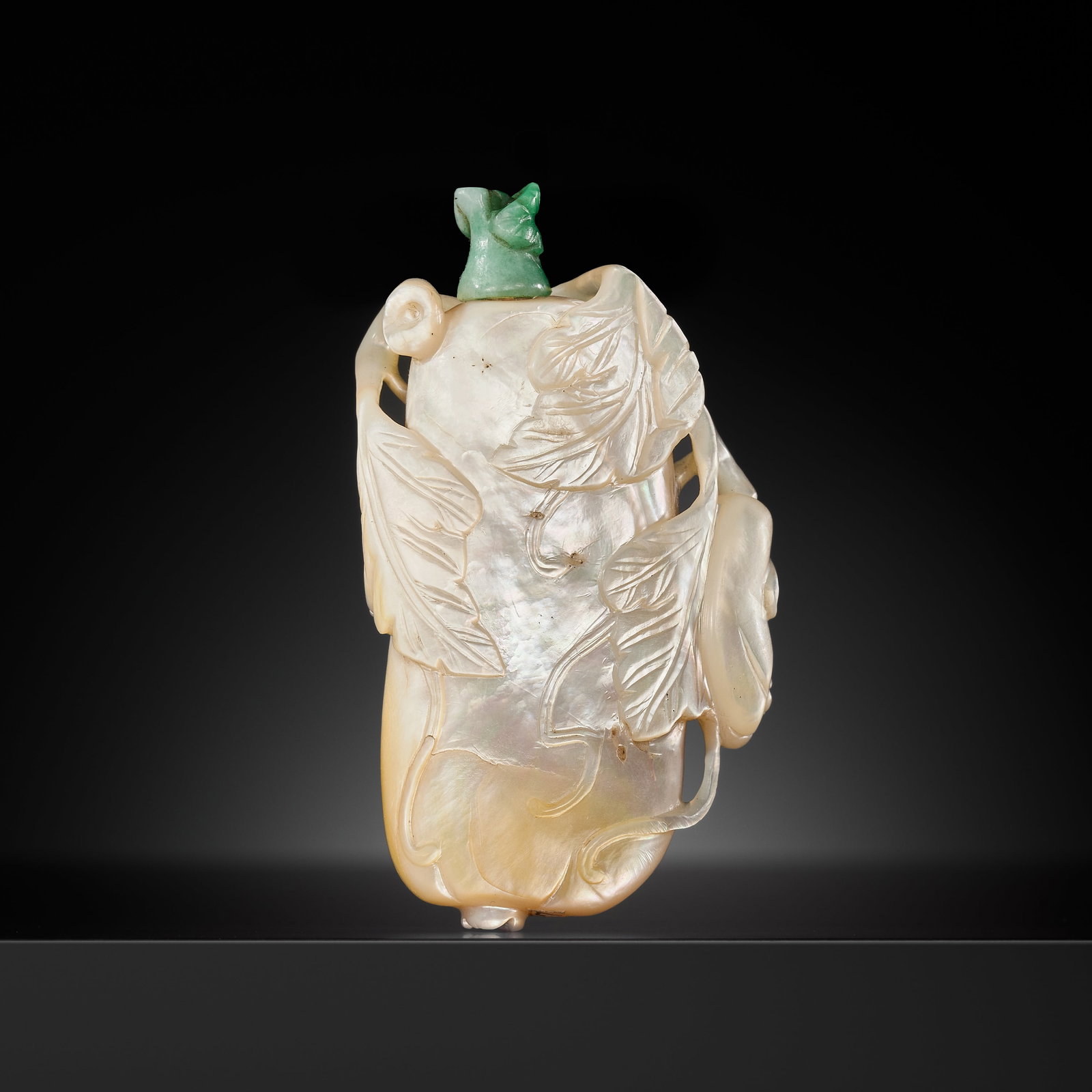 A MOTHER OF PEARL 'GOURD' SNUFF BOTTLE, 1750-1830: A MOTHER OF PEARL 'GOURD' SNUFF BOTTLE, 1750-1830 China. Delicately pierced and carved to suit the shape of the shell, intricately formed in the shape of an elongated melon, borne on an open worked gn