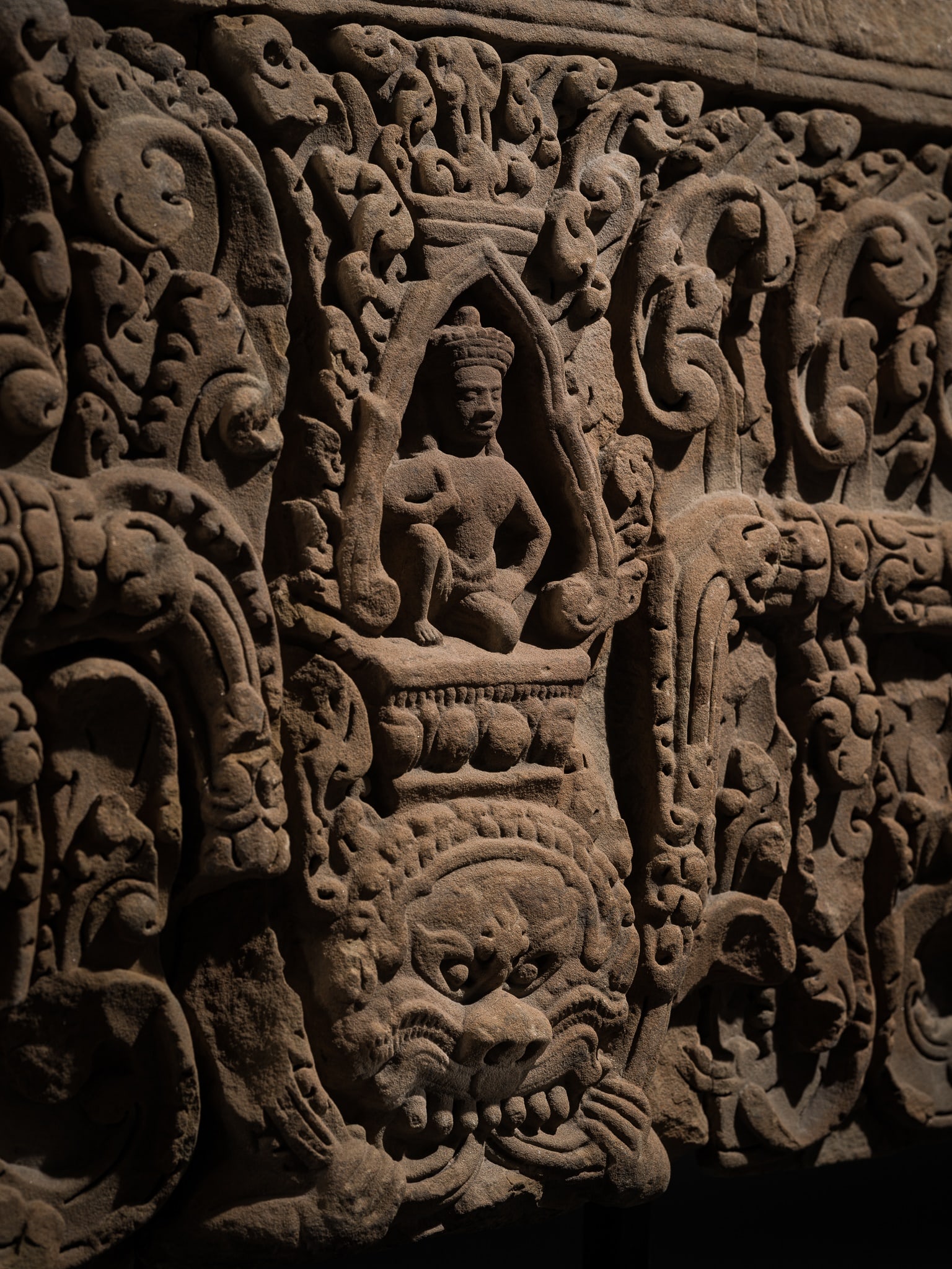 A RARE AND MASSIVE KHMER SANDSTONE 'YAKSHA AND KALA' LINTEL, BAPHUON STYLE, ANGKOR PERIOD, 11TH: A RARE AND MASSIVE KHMER SANDSTONE 'YAKSHA AND KALA' LINTEL, BAPHUON STYLE, ANGKOR PERIOD, 11TH CENTURY This lot is from a single owner collection and is therefore offered without reserve Magnificentl