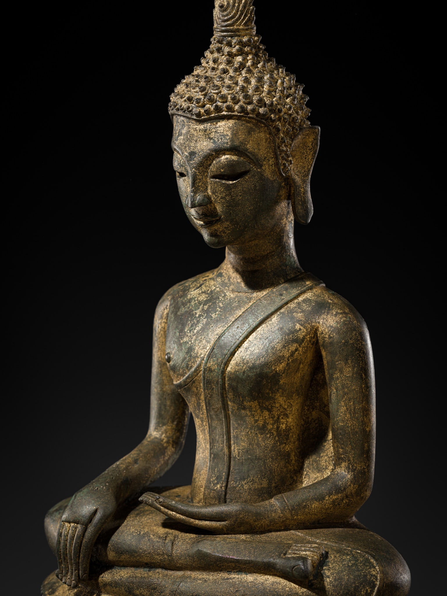 A GILT-LACQUERED BRONZE FIGURE OF BUDDHA SHAKYAMUNI, LAOS, 16TH-17TH CENTURY: A GILT-LACQUERED BRONZE FIGURE OF BUDDHA SHAKYAMUNI, LAOS, 16TH-17TH CENTURY This lot is from a single owner collection and is therefore offered without reserve Heavily cast, seated in virasana atop a