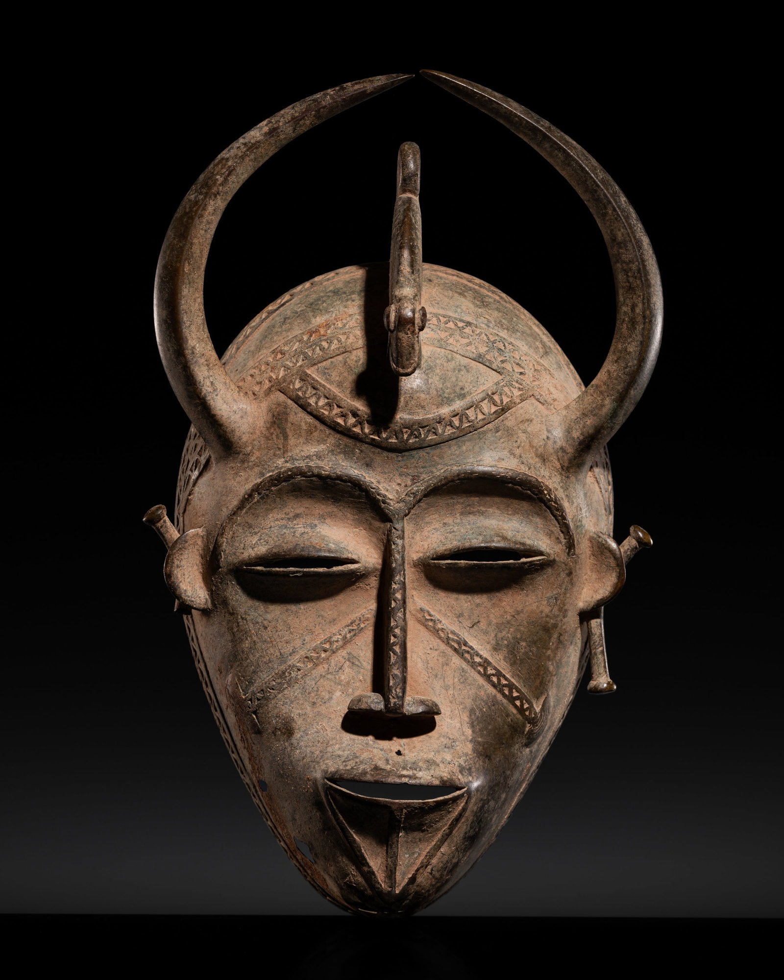 A SENUFO BRONZE MASK FOR THE DO SOCIETY, 19TH-20TH CENTURY: A SENUFO BRONZE MASK FOR THE DO SOCIETY, 19TH-20TH CENTURY This lot is from a single owner collection and is therefore offered without reserve Côte d'Ivoire. Of oval form, the face cast with arch