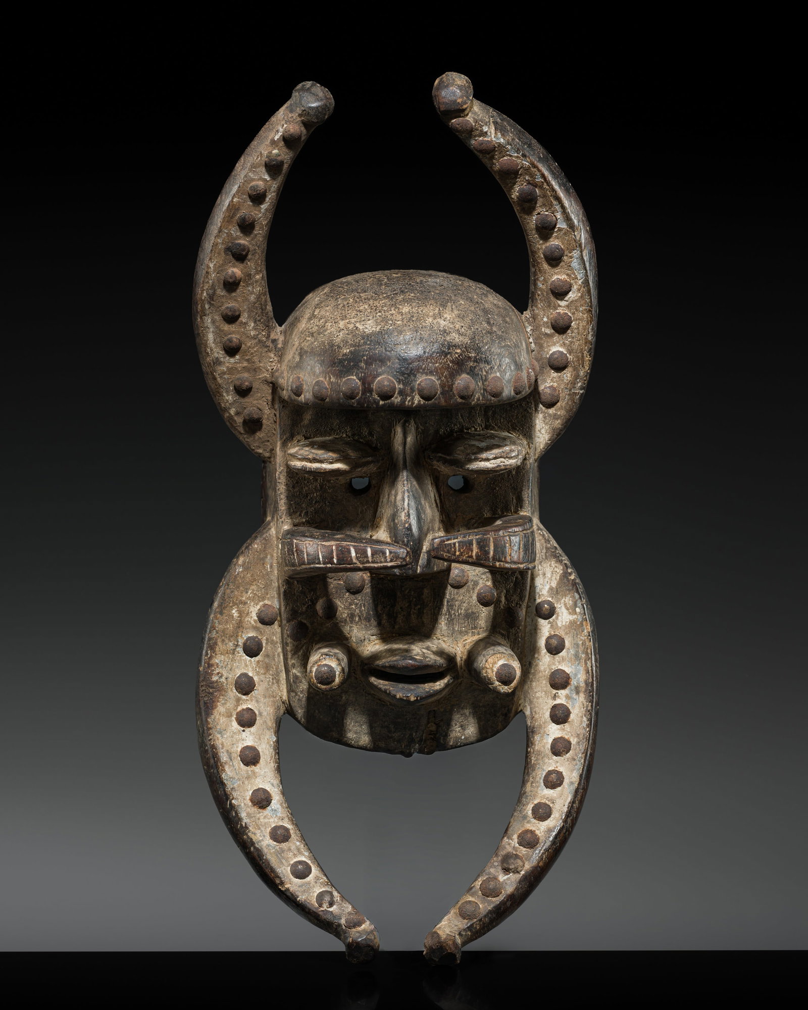 A GUERE WOOD AND IRON MASK, 20TH CENTURY: A GUERE WOOD AND IRON MASK, 20TH CENTURY This lot is from a single owner collection and is therefore offered without reserve Côte d'Ivoire. The rectangular face is framed by four outwardly curvin