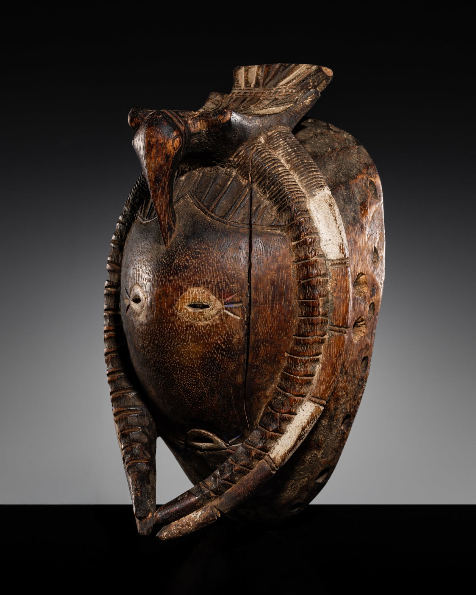 A KULANGO WOOD MASK: A KULANGO WOOD MASK This lot is from a single owner collection and is therefore offered without reserve Côte d'Ivoire, late 20th century. Of rounded ovoid form, the face reduced to a smooth round