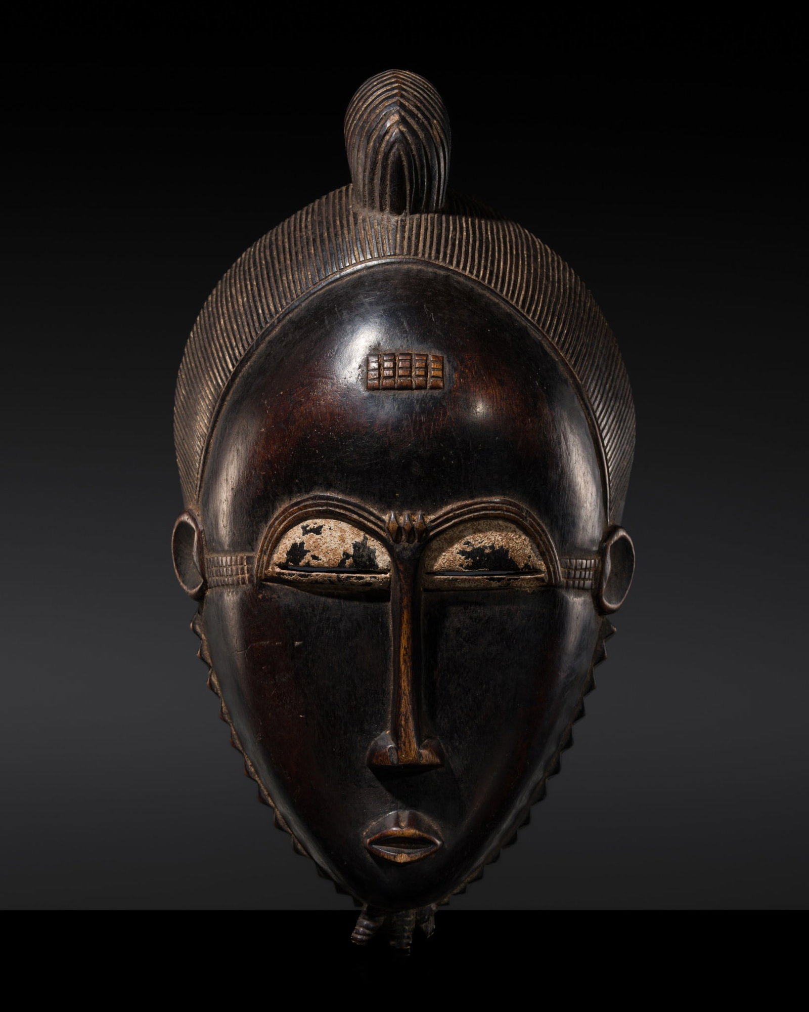 A YAURE WOOD MASK, 20TH CENTURY: A YAURE WOOD MASK, 20TH CENTURY This lot is from a single owner collection and is therefore offered without reserve Côte d'Ivoire. The ovoid face enclosed by a serrated border, with a serene expr