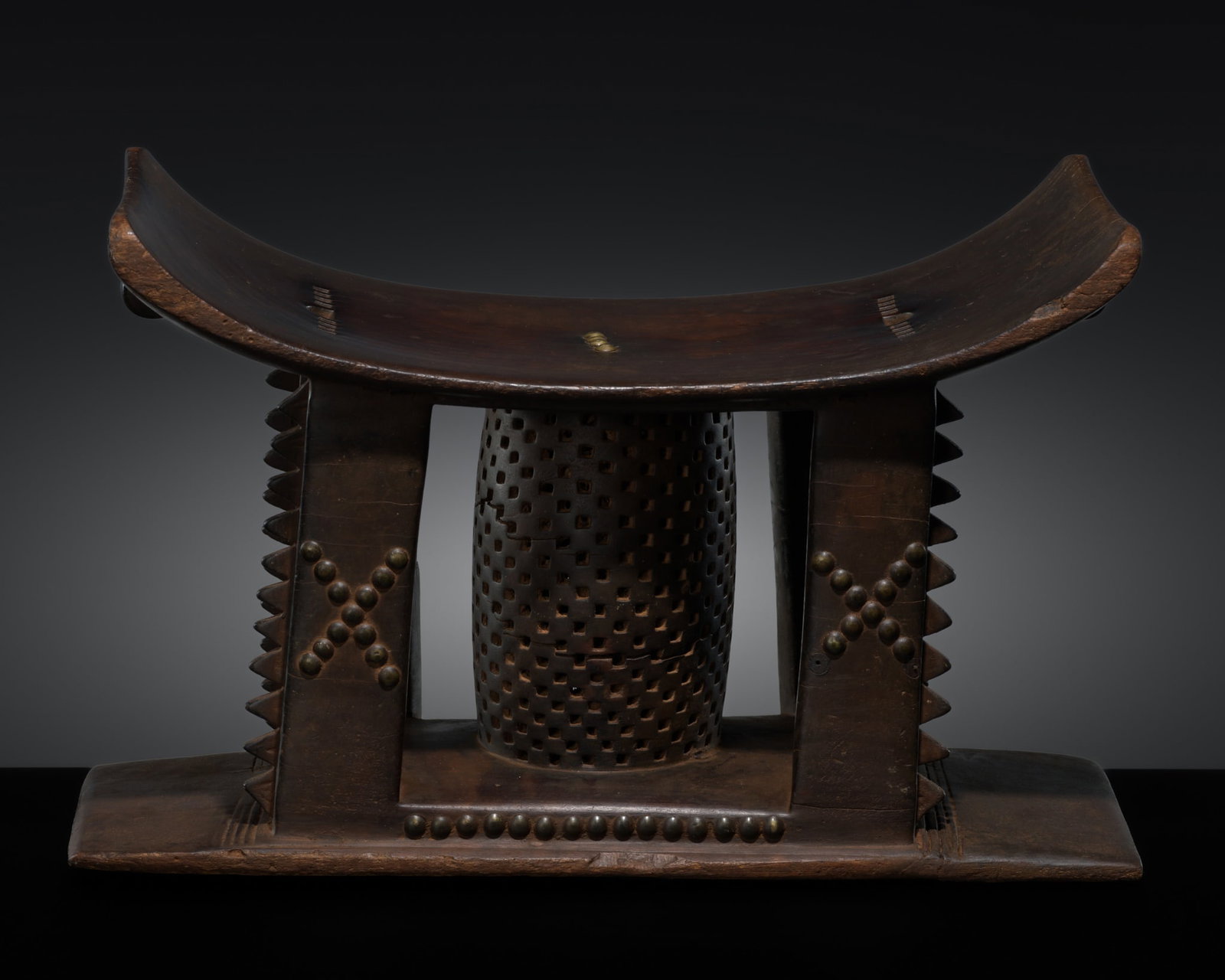AN ASHANTI WOOD 'CUBIST' CEREMONIAL STOOL, MMA DWA, 19TH-20TH CENTURY: AN ASHANTI WOOD 'CUBIST' CEREMONIAL STOOL, MMA DWA, 19TH-20TH CENTURY This lot is from a single owner collection and is therefore offered without reserve Ghana. Of typical form, the curved rectangular