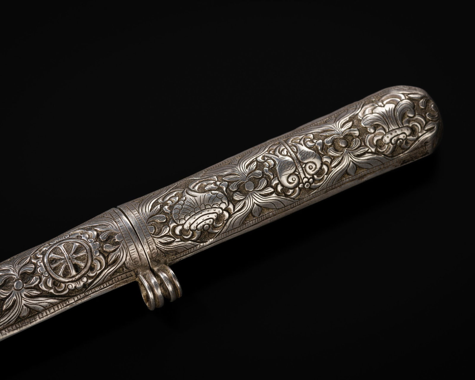 A FINE SILVER REPOUSSÉ 'EIGHT BUDDHIST EMBLEMS' PEN HOLDER, TIBET, 19TH CENTURY: A FINE SILVER REPOUSSÉ 'EIGHT BUDDHIST EMBLEMS' PEN HOLDER, TIBET, 19TH CENTURY This lot is from a single owner collection and is therefore offered without reserve Of elongated form with an oval 