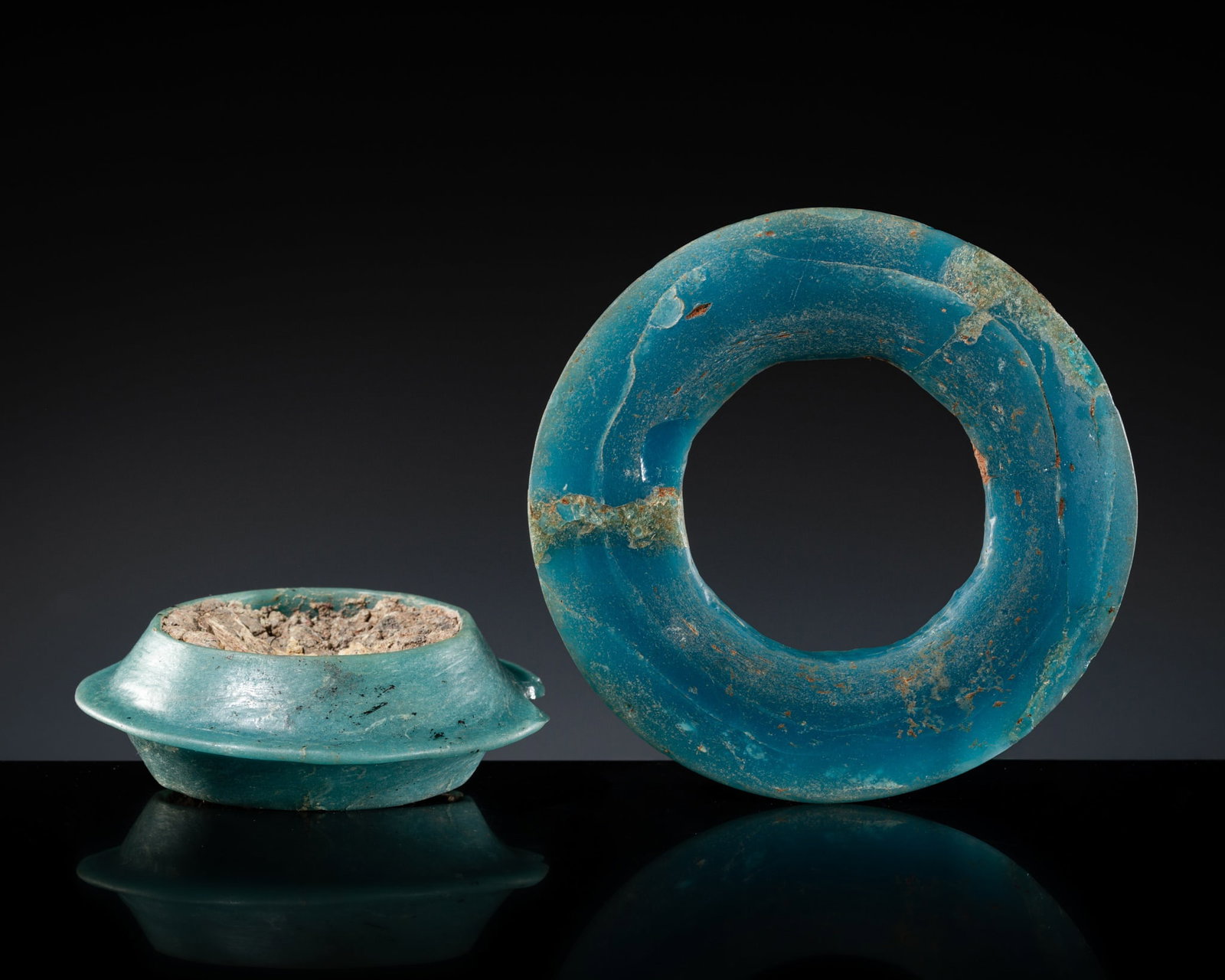 A GROUP OF AN AQUAMARINE GREEN GLASS BANGLE AND BI DISK, WARRING STATES PERIOD-HAN DYNASTY: A GROUP OF AN AQUAMARINE GREEN GLASS BANGLE AND BI DISK, WARRING STATES PERIOD-HAN DYNASTY This lot is from a single owner collection and is therefore offered without reserve China, 475 BC-220 AD. Eac