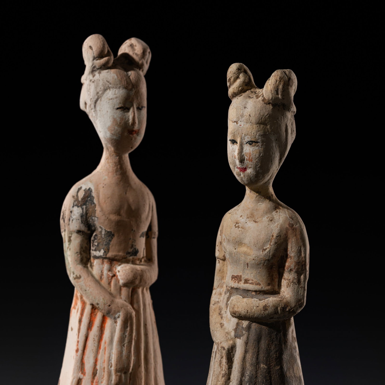 A SET OF TWO PAINTED POTTERY FIGURES OF COURT LADIES, TANG DYNASTY: A SET OF TWO PAINTED POTTERY FIGURES OF COURT LADIES, TANG DYNASTY This lot is from a single owner collection and is therefore offered without reserve China, 618-907. The ladies dressed in long flowin