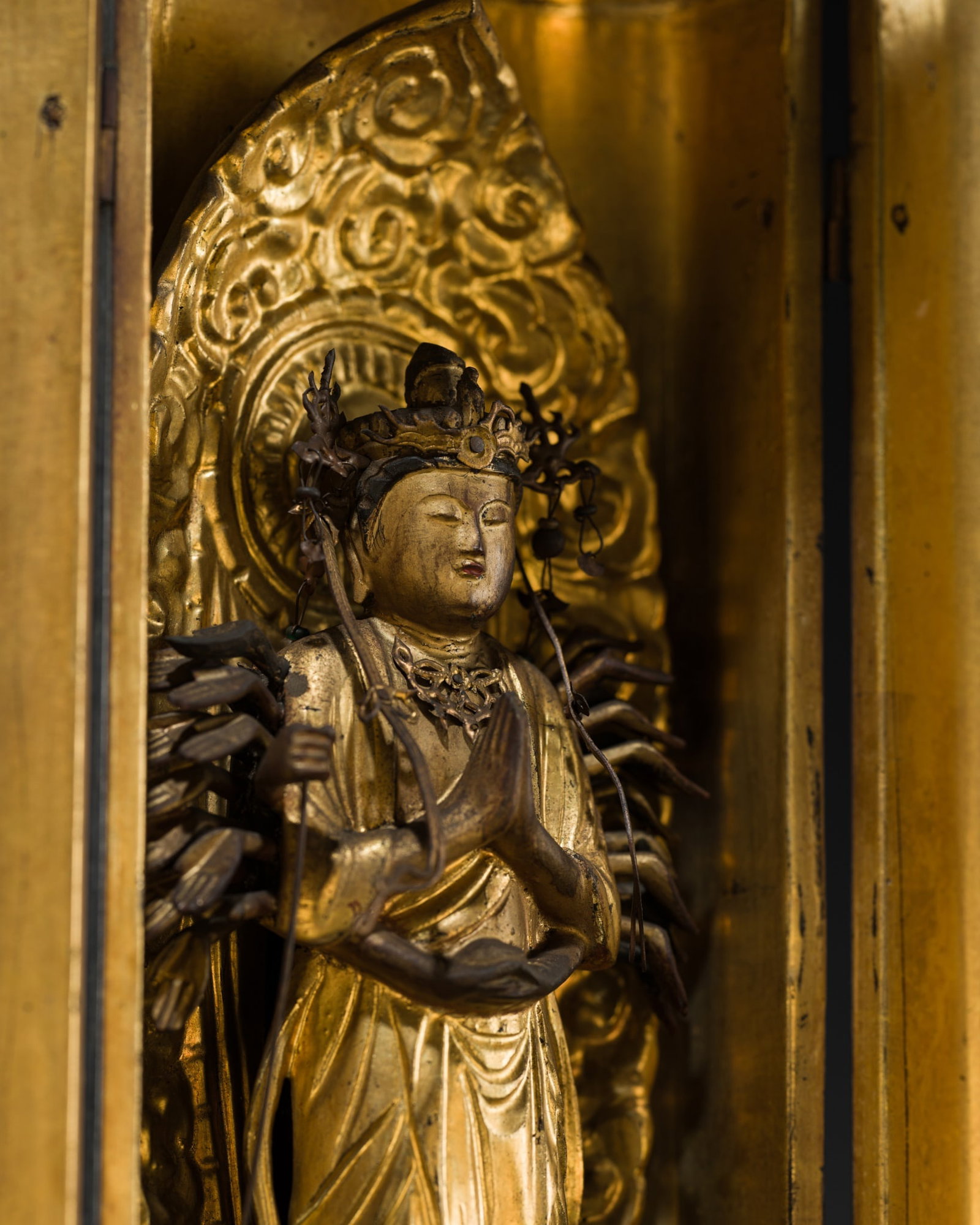 A MINIATURE ZUSHI (PORTABLE SHRINE) CONTAINING A GILT-LACQUERED FIGURE OF SENJU KANNON BOSATSU, 19TH: A MINIATURE ZUSHI (PORTABLE SHRINE) CONTAINING A GILT-LACQUERED FIGURE OF SENJU KANNON BOSATSU, 19TH CENTURY This lot is from a single owner collection and is therefore offered without reserve Japan, 