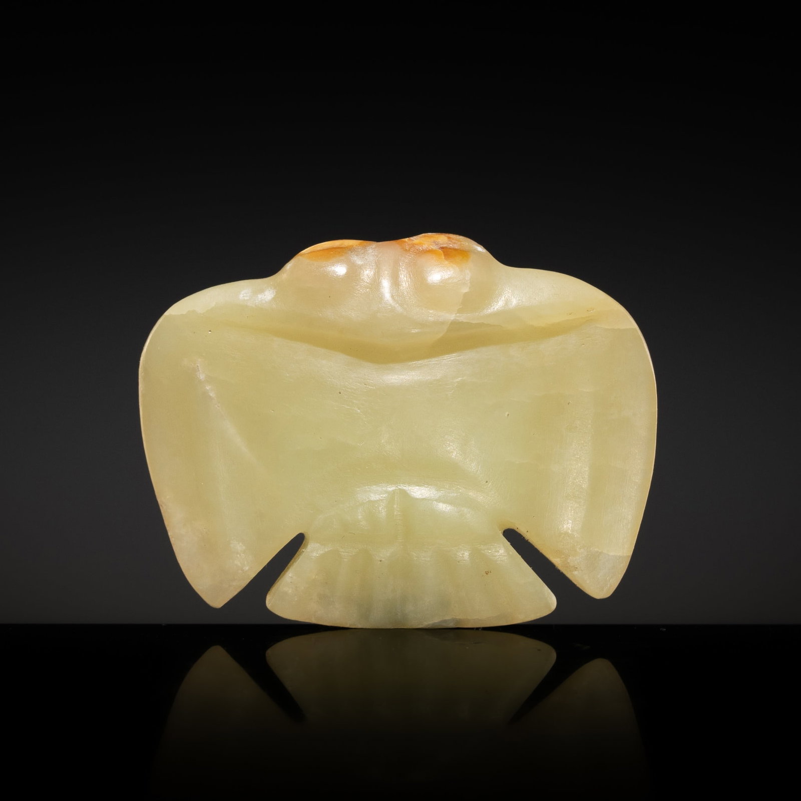 A YELOWISH CELADON AND RUSSET JADE 'BIRD' PENDANT, HONGSHAN CULTURE: A YELOWISH CELADON AND RUSSET JADE 'BIRD' PENDANT, HONGSHAN CULTURE China, 4700-2500 BC. Of flattened form, carved with protruding round eyes and prominent chest, the outstretched wings subtly detaile
