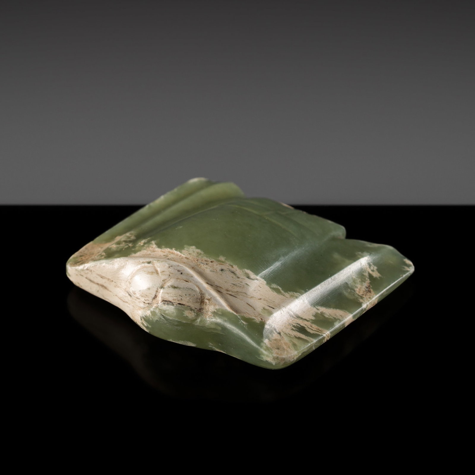 A GREEN JADE 'BIRD' PENDANT, HONGSHAN CULTURE: A GREEN JADE 'BIRD' PENDANT, HONGSHAN CULTURE China, 4700-2500 BC. Of flattened form, carved with protruding round eyes and prominent chest, the outstretched wings subtly detailed with grooves and rid