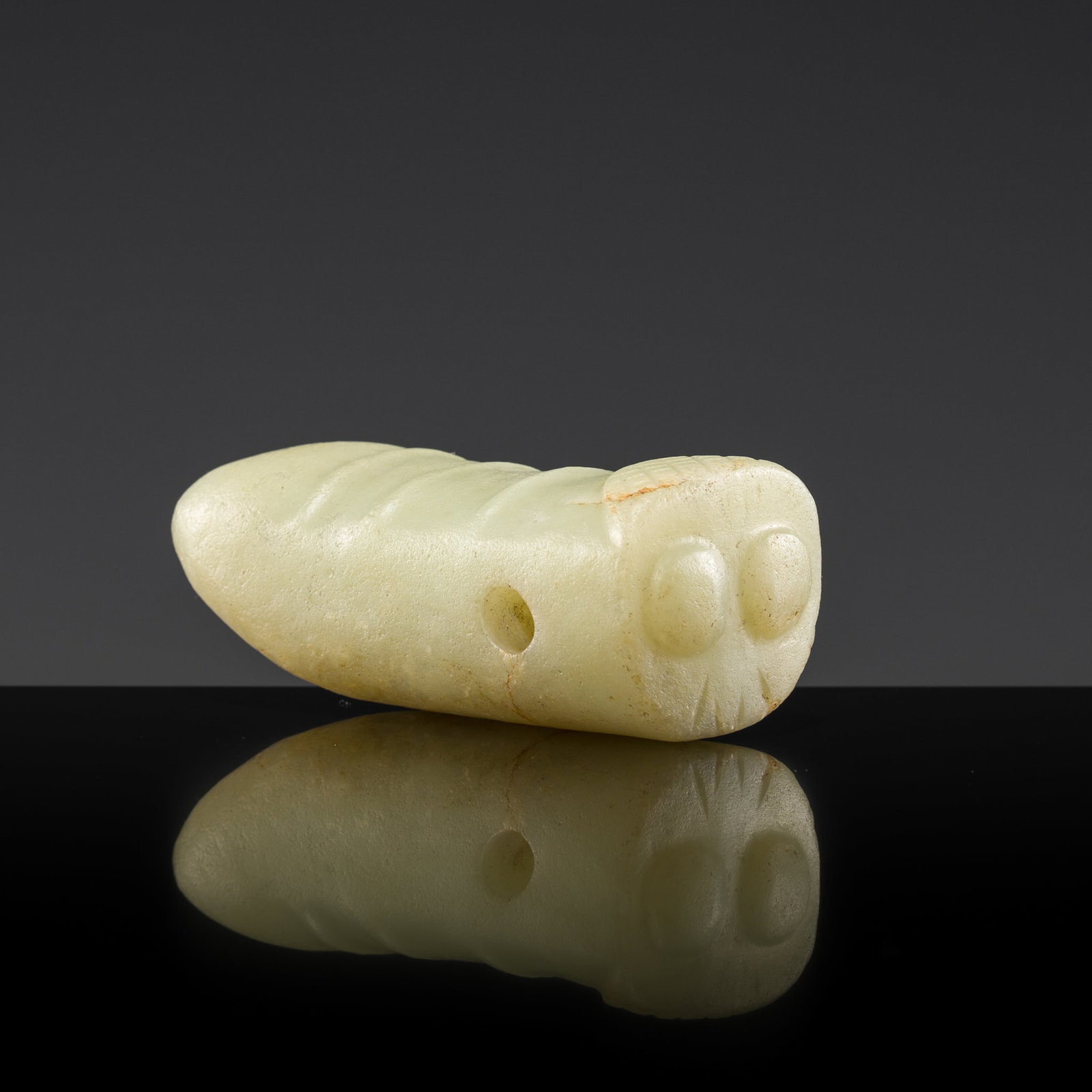 A CELADON JADE 'SILKWORM' PENDANT, HONGSHAN CULTURE: † A CELADON JADE 'SILKWORM' PENDANT, HONGSHAN CULTURE Expert authentication: Dr. Gu Fang has examined the present lot and confirms its authenticity and the dating above, noting the style of cutt