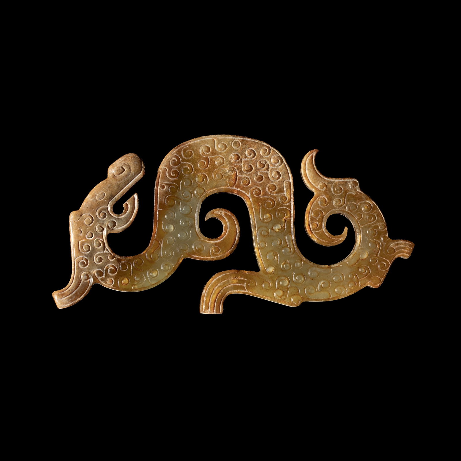 A YELLOWISH GREEN AND RUSSET JADE 'DRAGON' PENDANT, WARRING STATES: † A YELLOWISH GREEN AND RUSSET JADE 'DRAGON' PENDANT, WARRING STATES Expert authentication: Dr. Gu Fang has examined the present lot and confirms its authenticity and the dating above, noting th