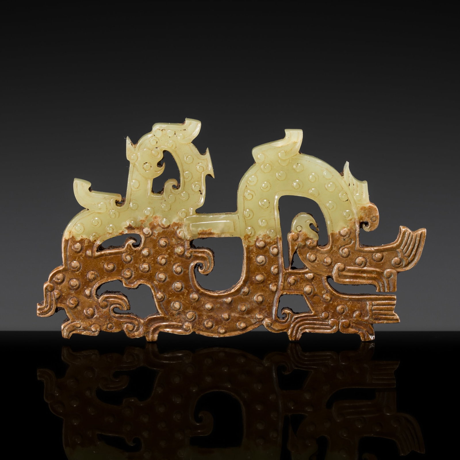 A YELLOWISH GREEN JADE 'DRAGON AND PHOENIX' PENDANT, WARRING STATES: † A YELLOWISH GREEN JADE 'DRAGON AND PHOENIX' PENDANT, WARRING STATES China, c. 475-221 BC. The flat plaque is finely carved as a dragon with a long, sinuous S-shaped body embellished with curle