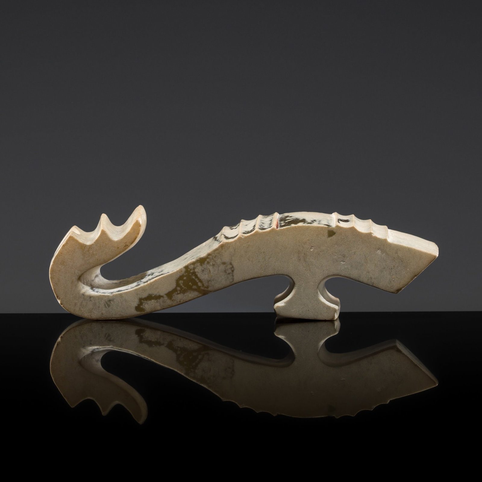 A CALCIFIED IVORY WHITE JADE 'DRAGON' BELT HOOK, WARRING STATES PERIOD: A CALCIFIED IVORY WHITE JADE 'DRAGON' BELT HOOK, WARRING STATES PERIOD China, 475-221 BC. Boldly carved, the curved shaft, of rectangular section, decorated with raised horizontal ridges, terminating 