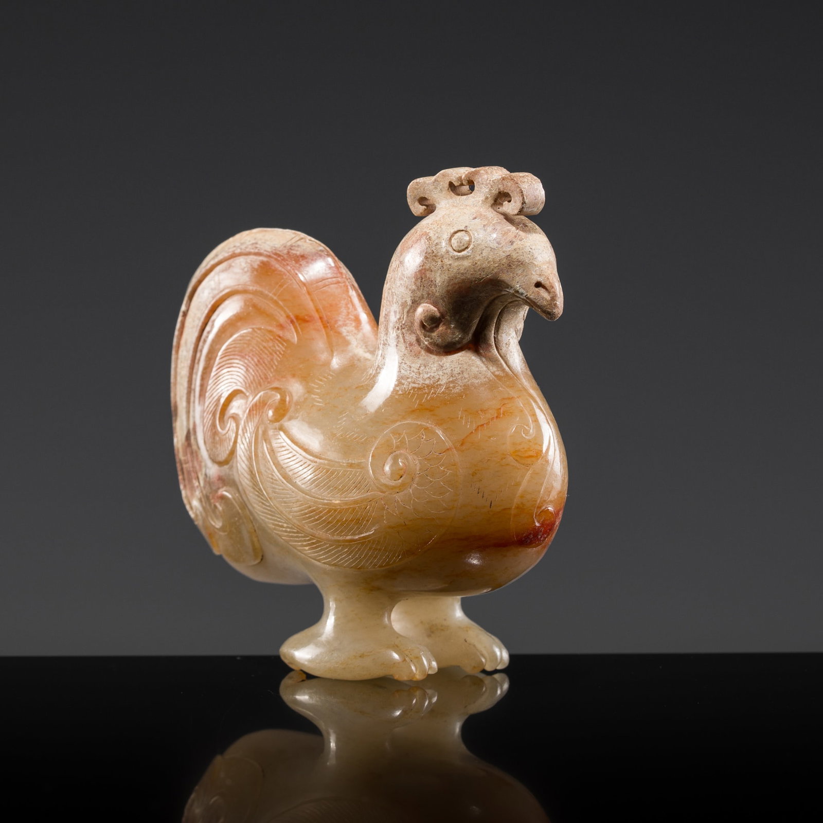 AN EXCELLENT PALE CELADON AND RUSSET JADE CARVING OF A COCKEREL, WESTERN HAN DYNASTY: AN EXCELLENT PALE CELADON AND RUSSET JADE CARVING OF A COCKEREL, WESTERN HAN DYNASTY China, 206 BC-9 AD. Exquisitely carved, the bird is depicted standing on well-defined legs, its oblong body decorat