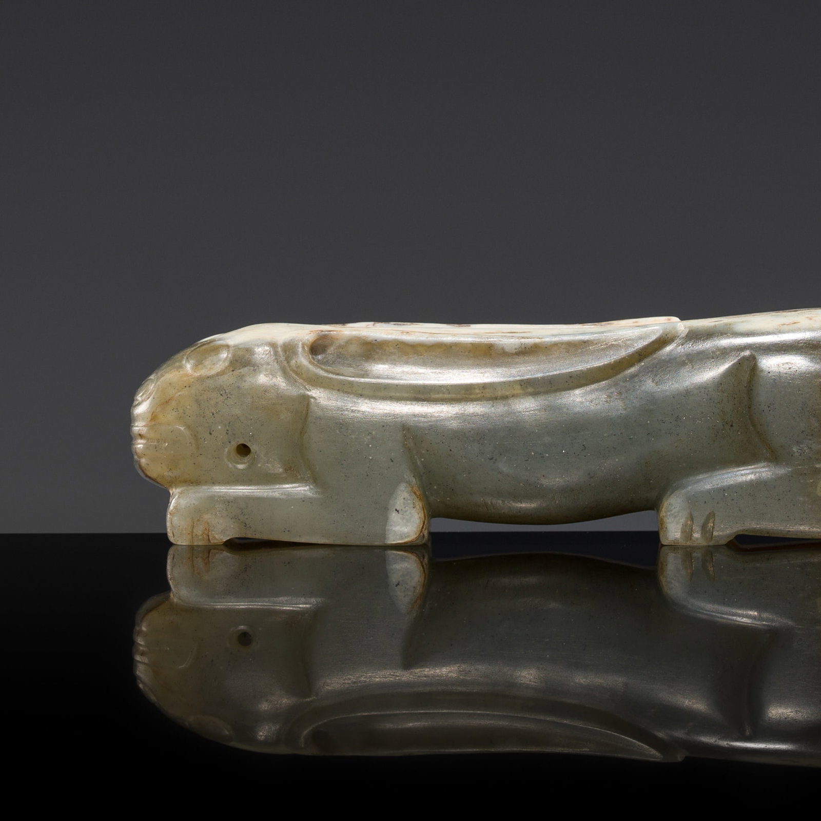 AN UNUSUAL MOTTLED JADE CARVING OF A RECUMBENT HARE, HAN DYNASTY (1 of 14)