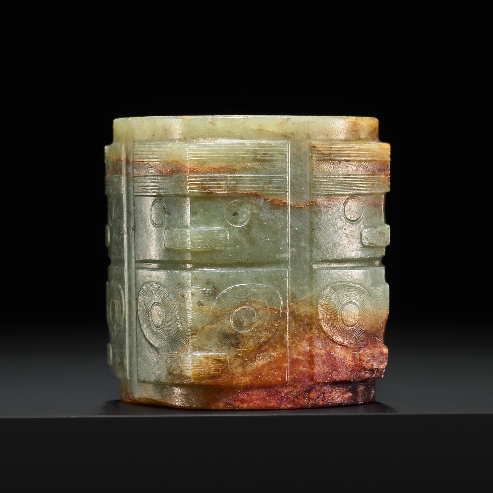 AN IMPORTANT GREEN AND RUSSET JADE TWO-TIERED CONG, LATE NEOLITHIC PERIOD, LIANGZHU CULTURE: AN IMPORTANT GREEN AND RUSSET JADE TWO-TIERED CONG, LATE NEOLITHIC PERIOD, LIANGZHU CULTURE China, c. 3300-2200 BC. Superbly carved, the thick walls articulated with squared projecting corners and div
