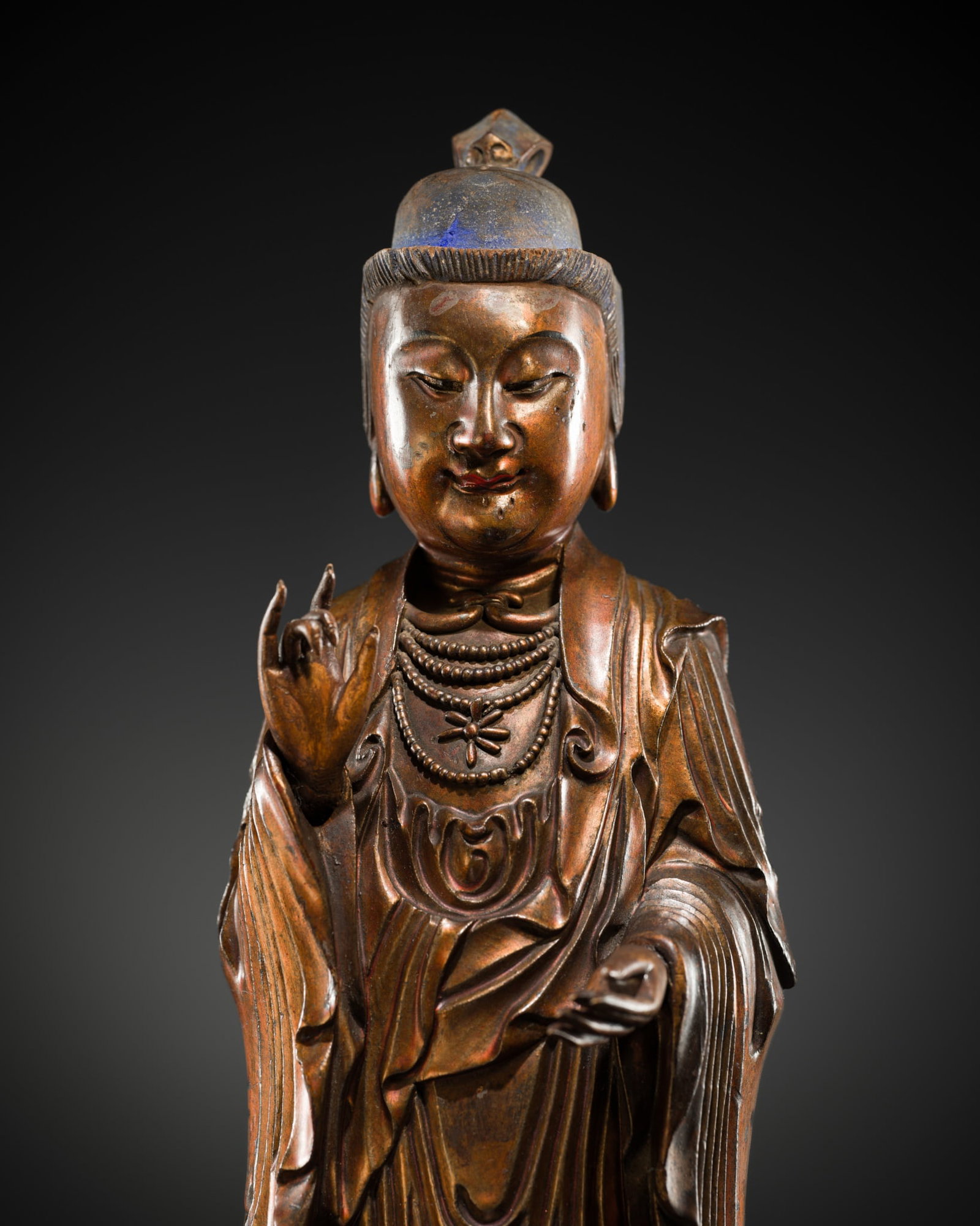 A GILT-LACQUERED WOOD FIGURE OF BUDDHA, 18TH-19TH CENTURY: A GILT-LACQUERED WOOD FIGURE OF BUDDHA, 18TH-19TH CENTURY China. Carved standing, the right hand raised in abhayamudra and the left lowered in varadamudra, wearing a long dhoti falling in crisp vertic