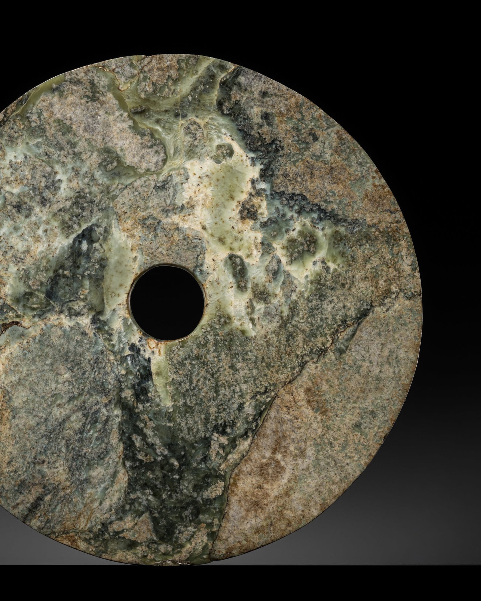 † AN EXCEPTIONALLY LARGE (45 CM) MOTTLED GREEN JADE DISK, BI, QIJIA CULTURE: † AN EXCEPTIONALLY LARGE (45 CM) MOTTLED GREEN JADE DISK, BI, QIJIA CULTURE Expert authentication: 1. Dr. Gu Fang has examined the present lot and guarantees its authenticity and the dating abov