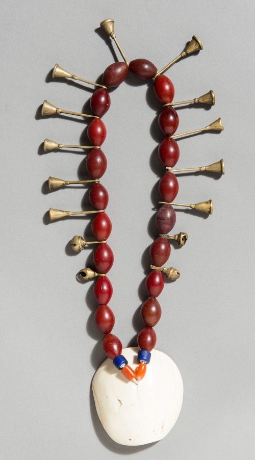 CHALCEDONY BEAD NECKLACE WITH CLAPPER BELLS AND JINGLE: INDIA, NAGA, 1st half of 20th cent. or earlier Yellow bronze, chalcedony, glass and shell. Attractive necklace of large, round and particularly dark chalcedony beads, similar to lot 464. Hanging betwe
