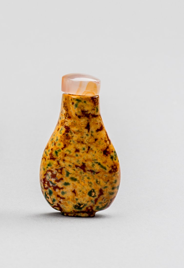 COLOURFUL, PATCHED MINIATURE BOTTLE: Glass. China, Qing, approx. 19th cent. Very small bottle with a bright and spirited pattern. Mustard-yellow base, many red-brown and green sprinkles. Beautiful polish, the well-fitting cap is a minera