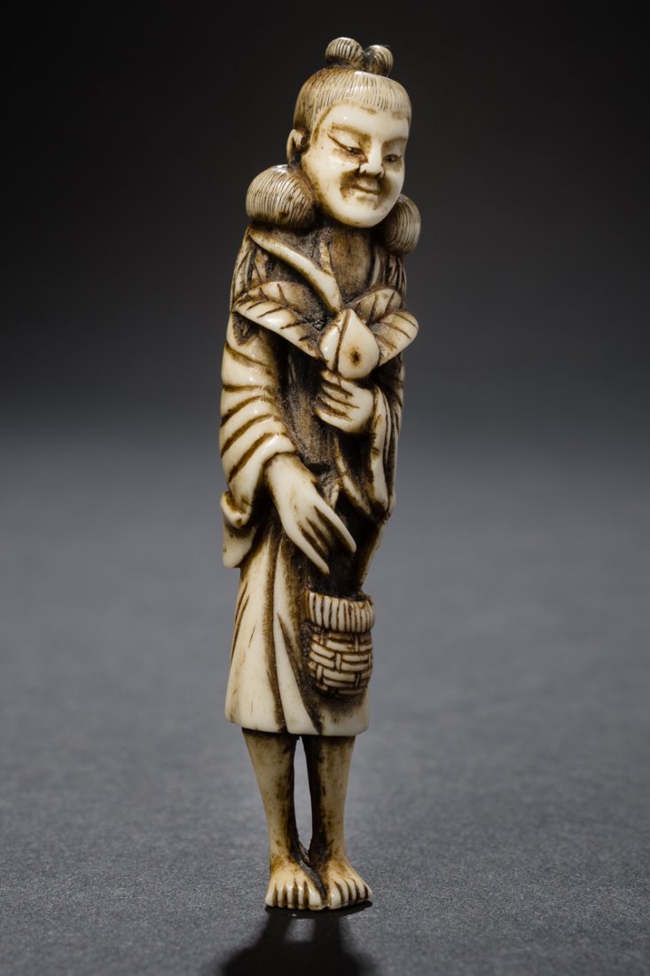 FAIRY SEIOBO WITH THE PEACH OF LONG LIFE: Netsuke, ivory. Japan, 19th cent. Seiobo is here depicted as slender tall lady and appears as sennin, recognizable by the yomogi-leaf robe. Her hair is amusing in the form of little balls around her s