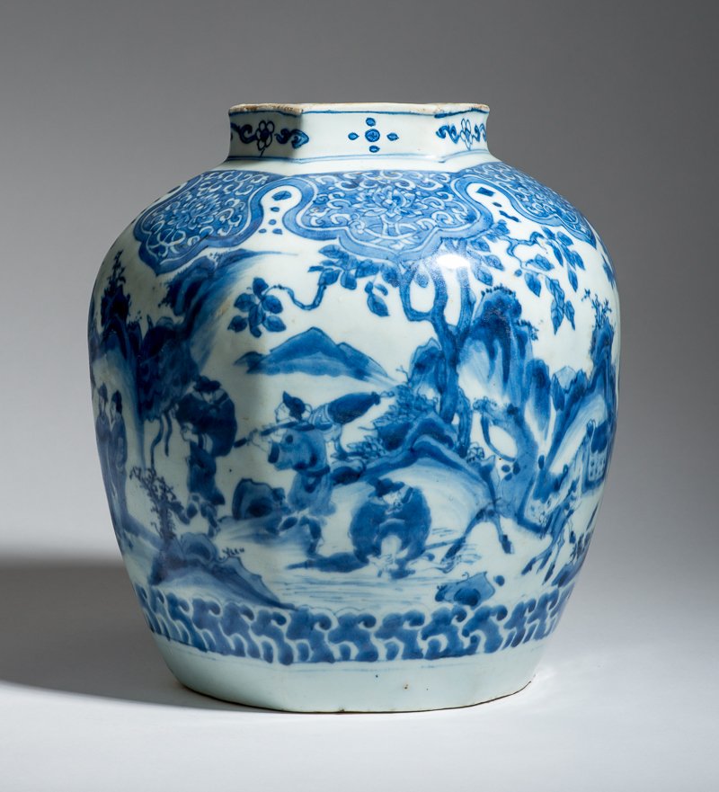 VESSEL WITH LANDSCAPE, SCHOLARS AND PAVILLONS: Porcelain with underglaze blue. China, 17th cent. An attractive blue-white vase from the late Ming dynasty, richly painted with varied depictions. A six-faceted body encompassed by a landscape paintin