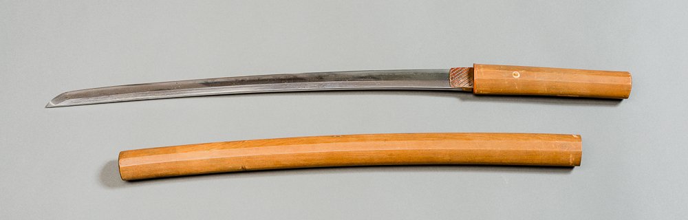 NORIMITSU: KO-KATANA SWORD IN SHIRASAYA: Japan. Shinto, approx. 16th cent. A short katana, almost a wakizashi. Iorimune and shinogi tsukuri, the interesting and lively hamon is suguha, partly with midare, with ashi and nioi, mokume-hada. The