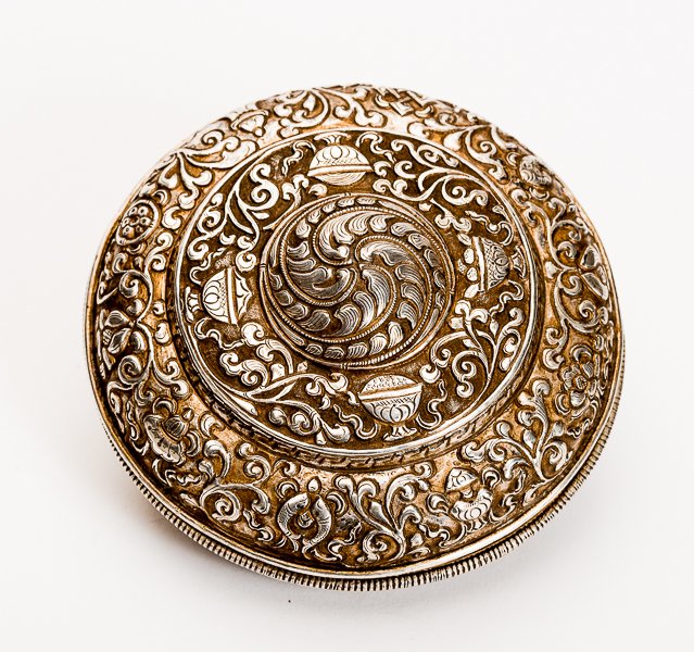 COVERED BOWL WITH ASHTAMANGALA: Silver. Tibet, 19th cent. Dense with repoussé decorated bowl, offering Buddhist Ashtamangala on the arched first step of the lid, including two fishes, conch horn, honorary umbrella, Wheel of the