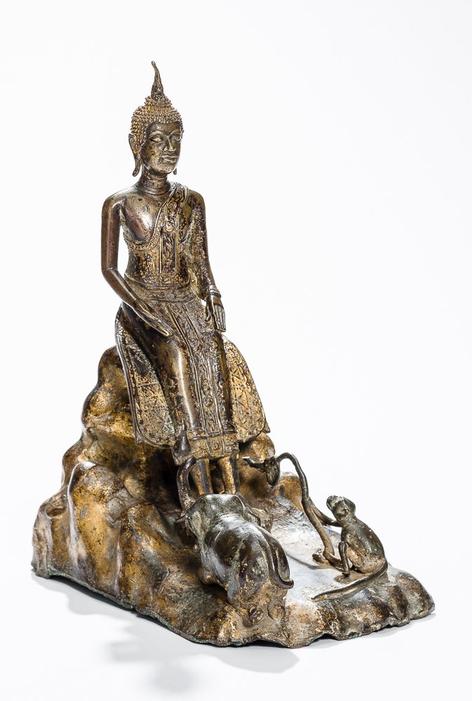BUDDHA SHAKYAMUNI ON ROCK THRONE AS WELL AS ELEPHANT: Bronze with gilding and lacquer technique. Thailand, Ratanakosin, 19th cent. A striking and rare depiction of Guatama Buddha seated on a rock, his bare feet on a round lotus pedestal. Very lean figure