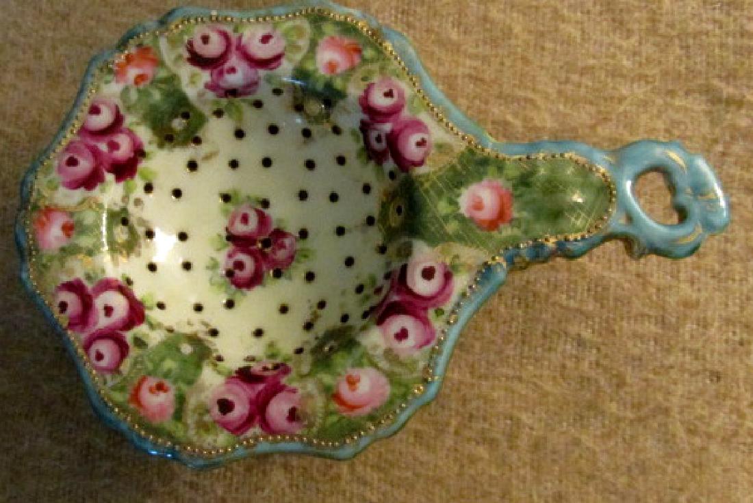 Hand Painted Nippon Tea Strainer: 1920s era, hand painted Nippon tea strainer with under bowl, red floral design, 6" long including the handle by 1 3/4" tall.