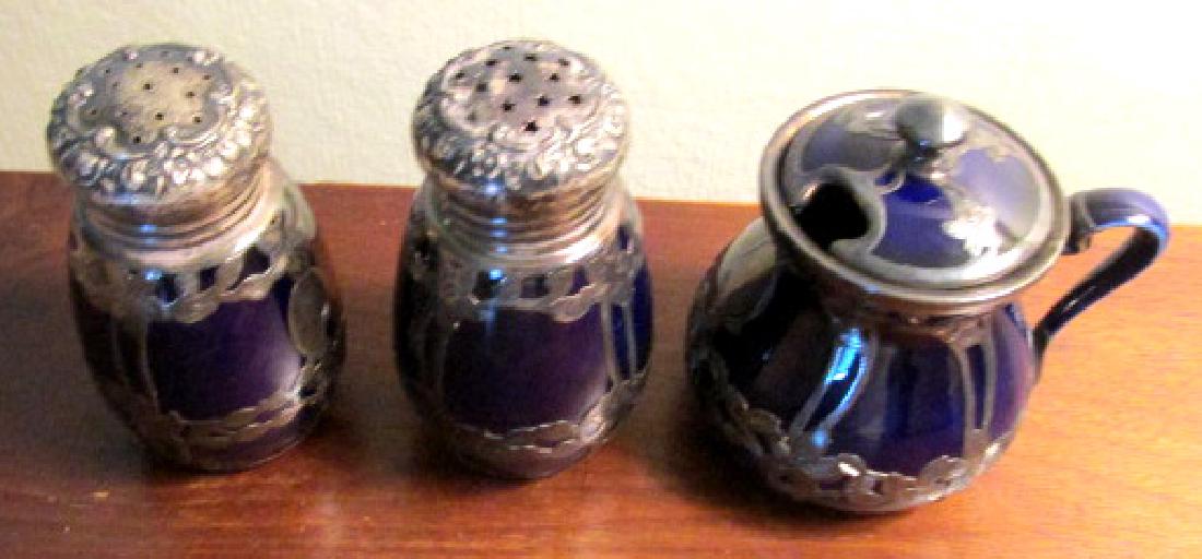 Porcelain by Lenox Silver Overlay Condiments: Stamped Sterling and the cobalt blue porcelain is by Lenox, salt and pepper with small jam pot, floral designs around the base, 3" tall.