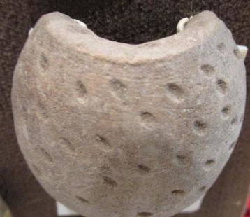 Pre-Columbian Clay Vessel Fragment: By 1958, the owner remembers this in the family home. From 500-1500 years old, likely Mexican. Clay fragment of half of a vessel having small indentations in the surface and a half circle opening in