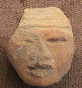 Pre-Columbian Clay Head Fragment: By 1958, the owner remembers this in the family home. From 500-1500 years old, likely Mexican, clay fragment of a human head, face has some damage to sides of head, nose and lips to the viewers left,