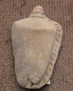 Pre-Columbian Clay Ornamental Object: By 1958, the owner remembers this in the family home. From 500-1500 years old, likely Mexican, clay ornamental object resembling an urn with top center finial that appears to be either a coil or