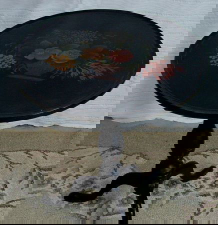 Black Tilt Top Decorated Table: Painted to resemble a tole or paper mache piece, pie crust edge, key is missing to holding the top to the base but stays as it should, tilts, 1950s era. Top Is 19" Diameter, 29 1/2 Tall.