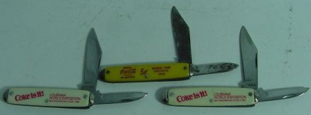 3 Authentic Coca Cola Worlds Fair Knives, Chicago: World Fair Chicago,1933 Knife Is A Yellow Celluloid Handled, 2 Bladed Pocket Knife Marked USA. The Logo Reads "Drink Coca Cola Trade Mark R In Bottles, 5c. The Celluloid And The Red Lettering Is In Ex