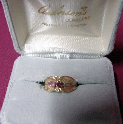 A 14K Mothers Ring: Pink and red stones that are simulated and about .03 each, 4.2 grams of 14K yellow gold, textured surface to the ring, Florentine or textured finish, prong setting on the stones, late 1950s or early 6