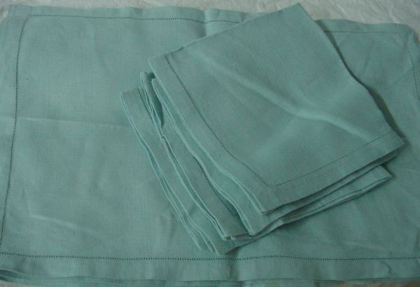 A Set of 4 Blue Linen Place Mats & Napkins: Light blue linen placemats measuring some 18" long by 12" tall, 15 x 15", good condition.