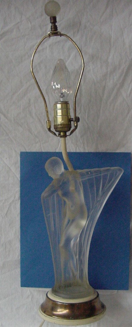 A Art Deco Lalique Style Lamp: A nude lady is holding a flowing cloak around her back side, pretty hair, lightly frosted surface all over the glass, good fold lines, very detailed, no signature visible, the glass figure is standing