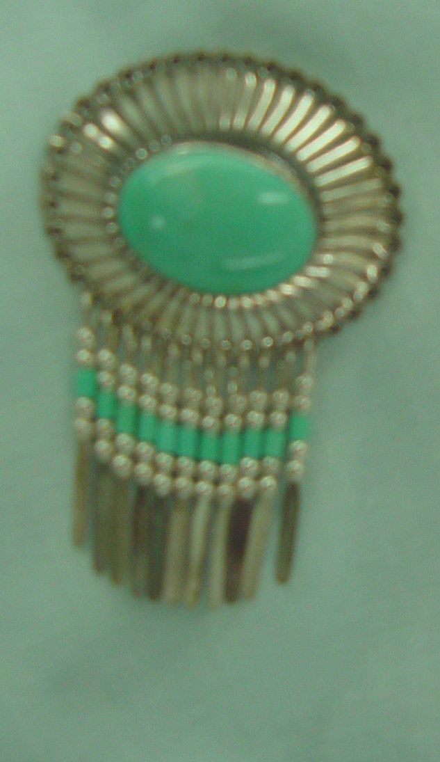 A Native American Silver & Turquoise Pin: Oval bezel set cabochon turquoise stone with an almost sunray behind the mounting and close to feathers with turquoise beads below, excellent condition, marked 925 and QTC.1 1/2" wide by 2" tall.